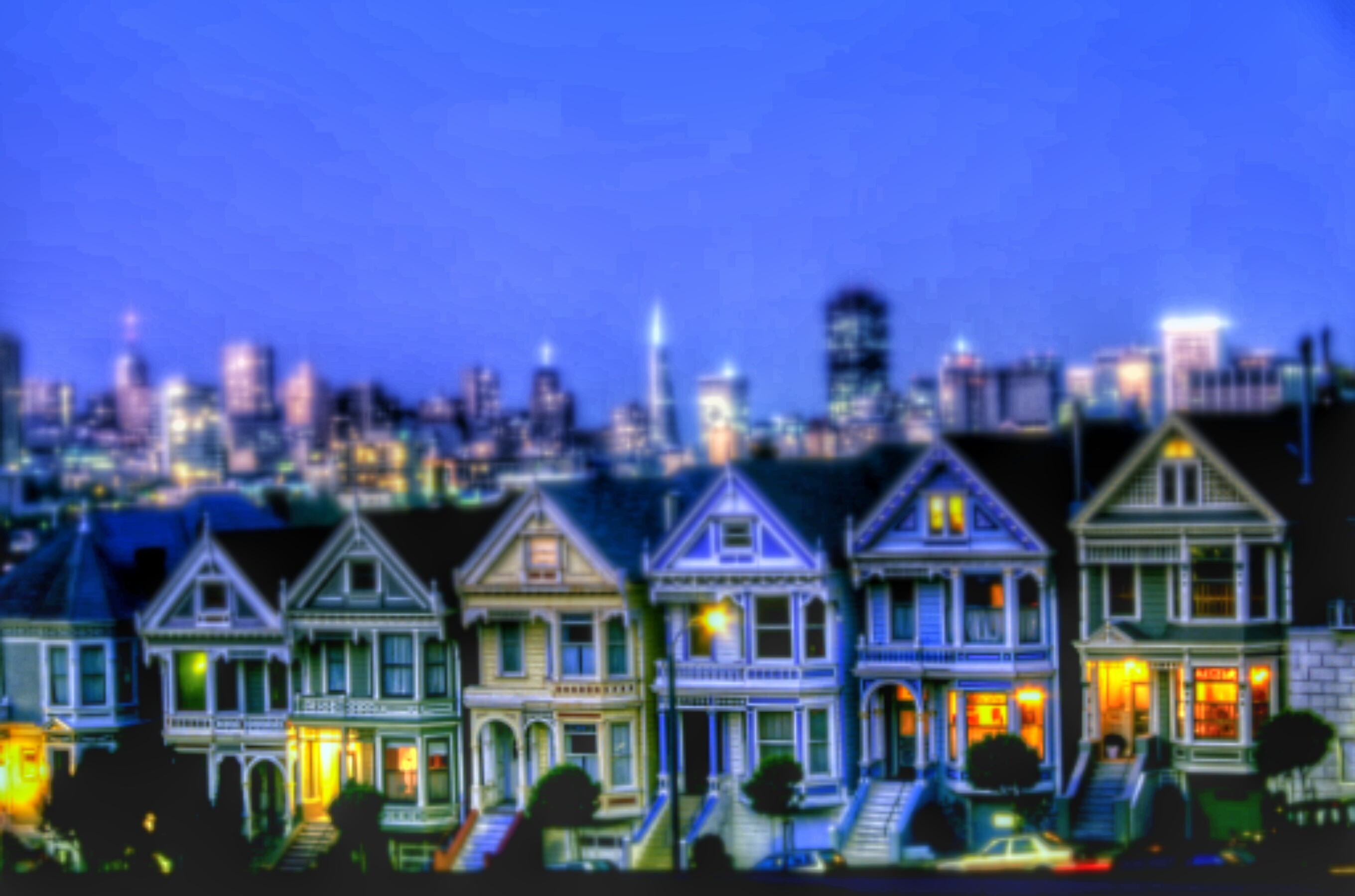 Painted Ladies Houses By Illuminated Urban Skyline Against Sky At Night