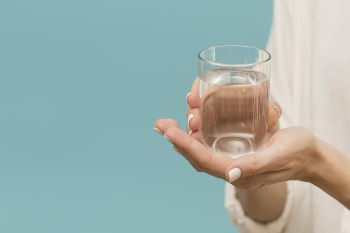woman holding glass filled with water