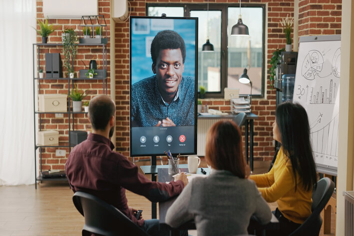 Group of workers using remote video call to talk to man about business growth on computer. Team of people meeting to discuss marketing collaboration on online internet teleconference.