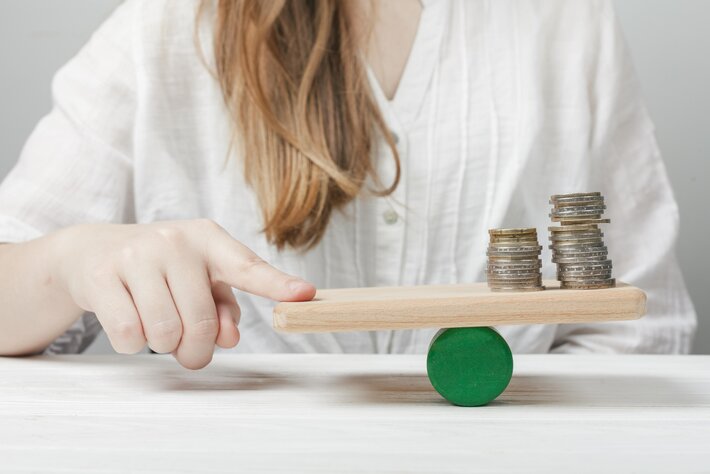 woman holding her finger balance with coins